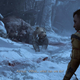 Atreus, in the snow, walks toward a young bear cub and its dead mother.